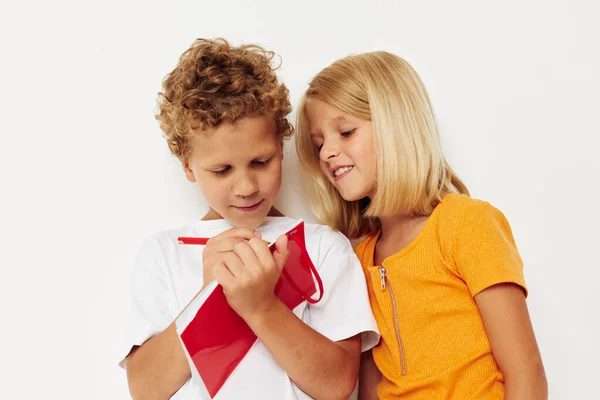 Diversión alegre de los niños en camisetas coloridas con un fondo del color del bloc de notas inalterado —  Fotos de Stock