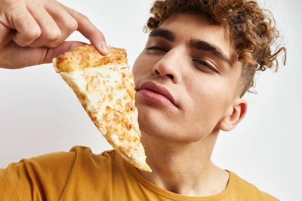 Красивий молодий чоловік їсть піцу позує крупним планом Стиль життя незмінний — стокове фото