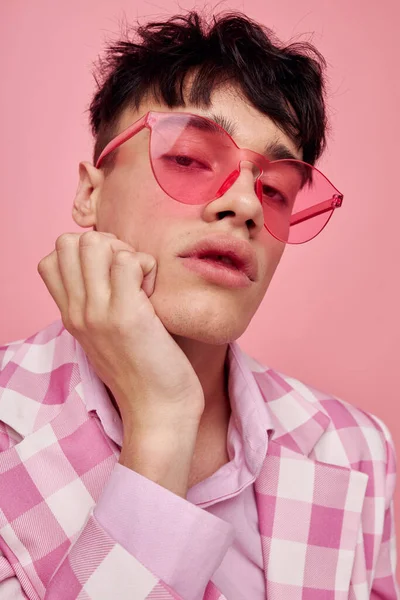 Yakışıklı adam pembe gözlüklü, kareli ceket modasında. Yaşam tarzını değiştirmemiş.