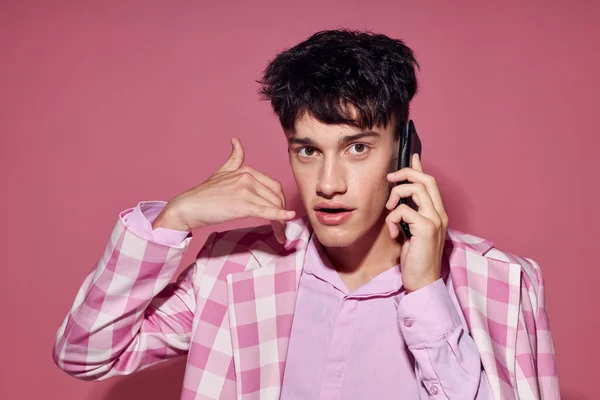 可愛い男ファッショナブルな話上の電話ピンクのブレザーポージングスタジオライフスタイル変更なし — ストック写真