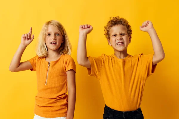 Two joyful children casual wear games fun together posing on colored background — Fotografia de Stock
