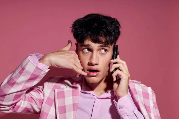 Πορτρέτο ενός νεαρού άνδρα με ένα τηλέφωνο στο χέρι ροζ σακάκι μόδας κομψό στυλ Lifestyle αμετάβλητη — Φωτογραφία Αρχείου