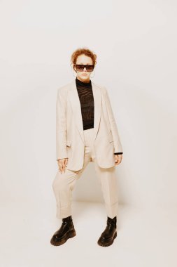 Güzel bir kadın. Klasik takım elbiseli. Güneş gözlüklü.