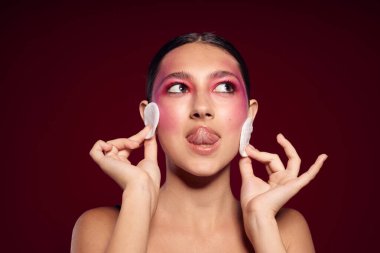 Güzel kadın pembe yüz makyajı çekici görünüş pembe arka plan değiştirilmemiş.