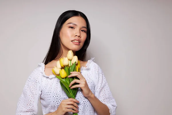 Kvinna med asiatiskt utseende romantik bukett blommor nära ansiktet ljus bakgrund oförändrad — Stockfoto