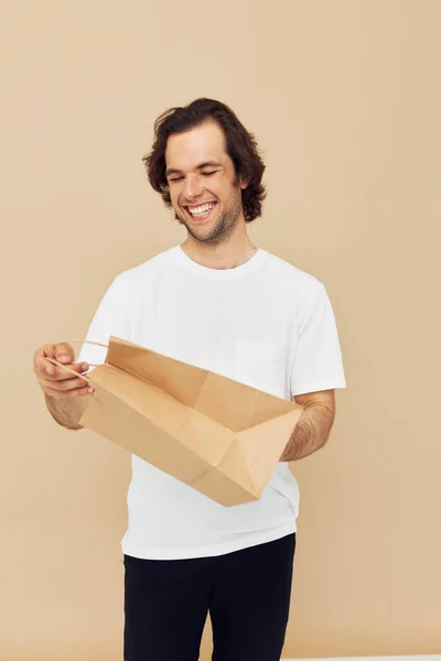 Веселий чоловік у білій футболці з паперовим мішком Стиль життя незмінний — стокове фото