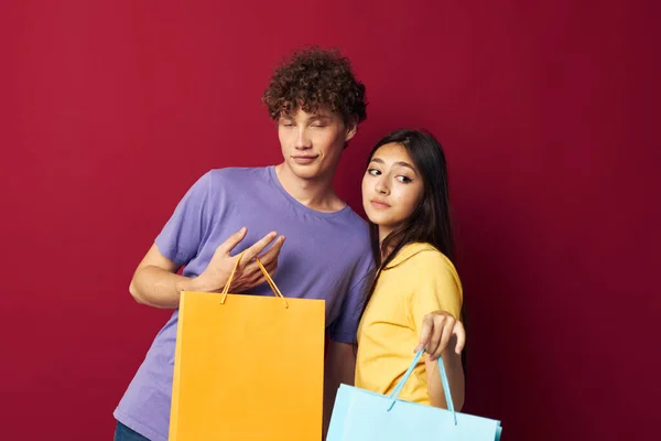 Мила молода пара барвисті сумки покупки весело ізольований фон незмінний — стокове фото