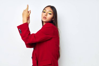 Kırmızı ceketli güzel esmer. Kozmetik tebessümlü. Arka planı değişmemiş.