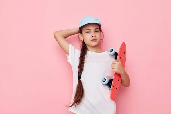 Gorra chica bastante joven en camiseta blanca monopatín estilo de vida inalterado — Foto de Stock