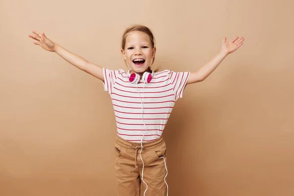 Słodkie dziewczyna w paski t-shirt słuchawki gest ręce odizolowane tło — Zdjęcie stockowe