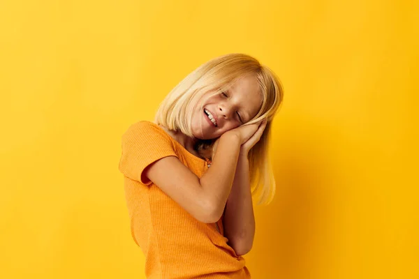 Sarı tişörtlü kız tebessümü ile stüdyo renginde poz veriyor. — Stok fotoğraf