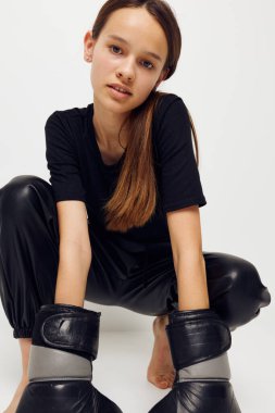 Siyah pantolonlu, boks eldivenli, genç ve güzel bir kadın.