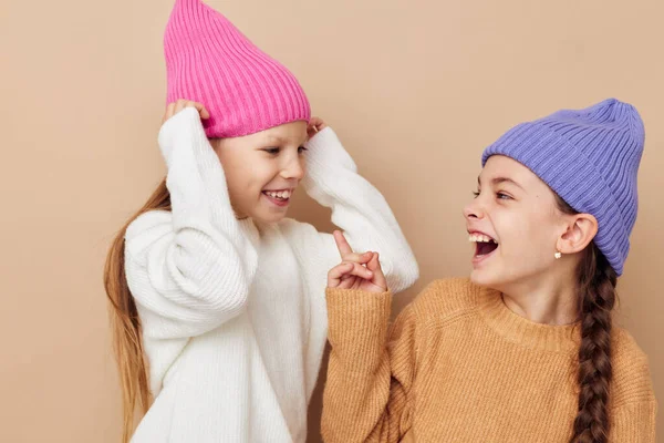 Δύο μικρά κορίτσια στέκονται το ένα δίπλα στο άλλο με καπέλα συναισθήματα μόδας — Φωτογραφία Αρχείου