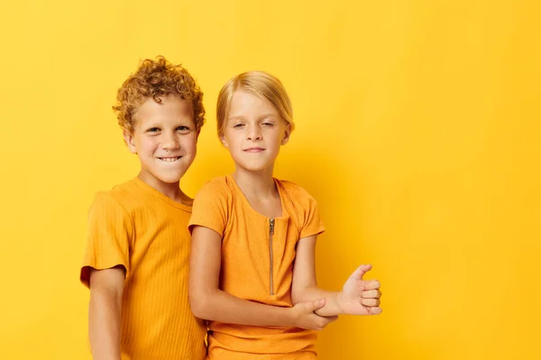 Portrait d'enfants mignons câlins mode enfance divertissement fond jaune inchangé — Photo