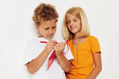 Küçük çocuklar not defterinin yanında durur. Duyguları hafif arkaplan çizer.