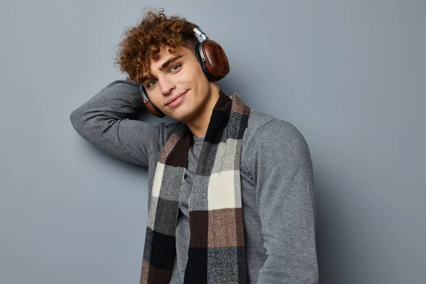 Guapo joven elegante estilo a cuadros bufanda auriculares aislados fondo — Foto de Stock