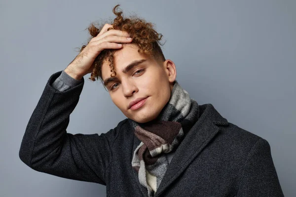 Siyah ceketli çekici bir adam modadan soyutlanmış arka plan.