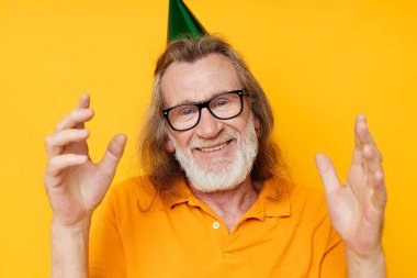 Sarı tişörtlü, kafasında şapkası olan emekli yaşlı bir adamın fotoğrafı.