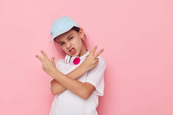 Ładna młoda dziewczyna słuchawki w białym t-shirt i czapka dzieciństwo bez zmian — Zdjęcie stockowe