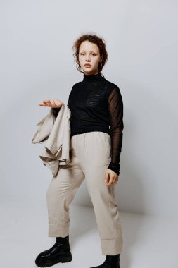 Güzel bir kadın, klasik bir takım elbiseyle, duyguları sarı arka planda pozlandırıyor.