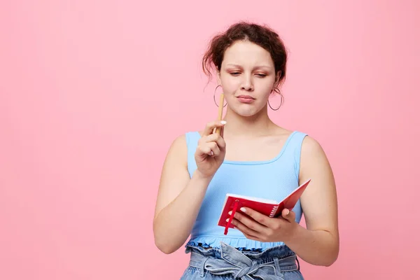 Jeune femme apprenant avec ordinateur portable et stylo fond de couleur rose inchangé — Photo