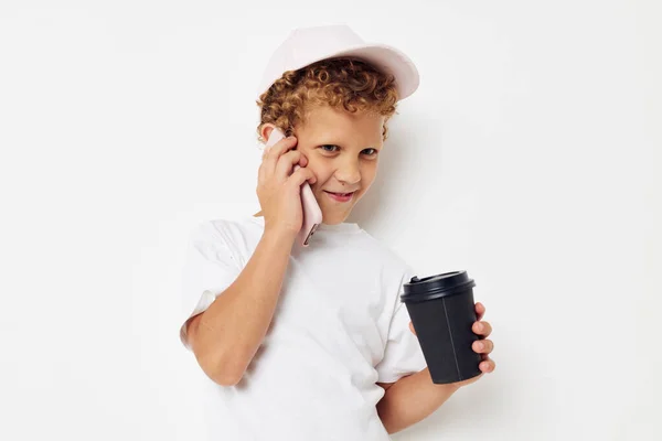 Foto retrato rizado niño qué tipo de bebida es el teléfono en la mano comunicación aislado fondo inalterado — Foto de Stock
