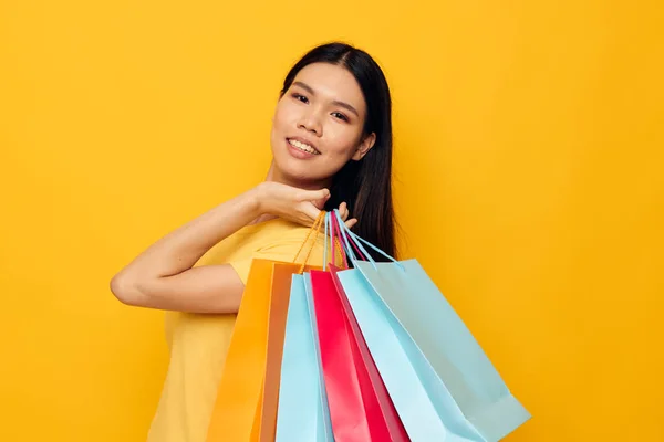 Portret aziatische mooie jonge vrouw met pakketten in handen winkelen geïsoleerde achtergrond ongewijzigd — Stockfoto
