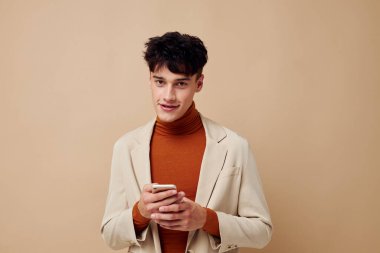 Moda ışığı arka planında değişmemiş bir şekilde iletişimde olan genç bir adam cep telefonu.