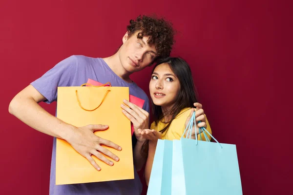 Портрет чоловіка і жінки в барвистих футболках з сумками Покупки Стиль життя незмінний — стокове фото