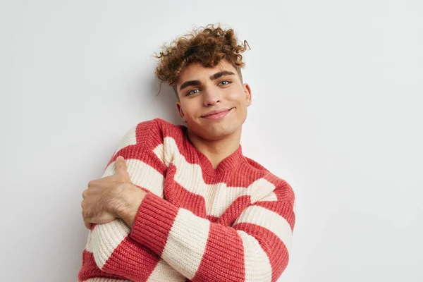 Handsome guy in a striped sweater posing light background — Φωτογραφία Αρχείου
