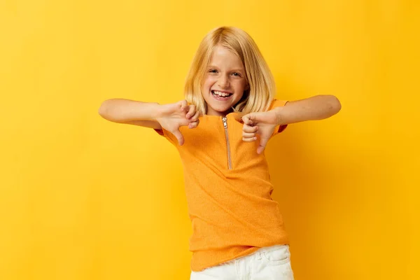 Sarı tişörtlü genç sarışın kız gülümsüyor. Stüdyoda çocukluk yaşam tarzını değiştirmemiş gibi gösteriyor. — Stok fotoğraf