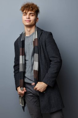 Siyah ceketli çekici bir adam modadan soyutlanmış arka plan.