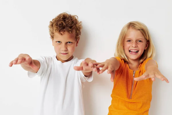 손으로 미소짓는 즐거움을 주는 두 어린이가 가벼운 배경을 입고 있다 — 스톡 사진