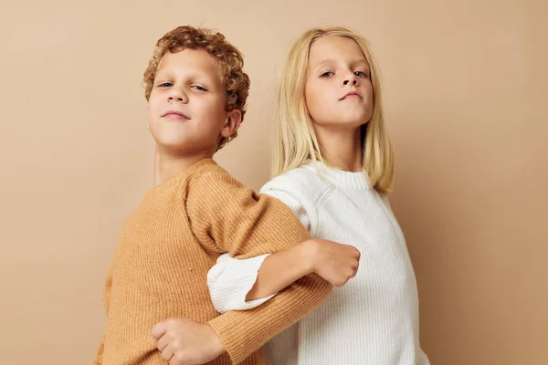 Niño y niña de pie junto a posar emociones de fondo beige — Foto de Stock