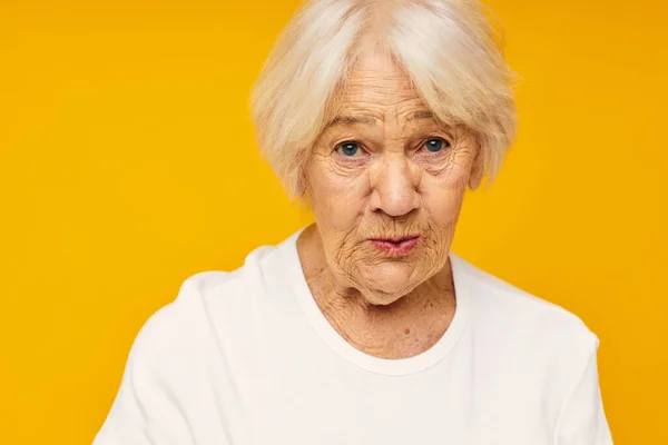 Foto de anciana jubilada posando cara mueca alegría fondo amarillo — Foto de Stock
