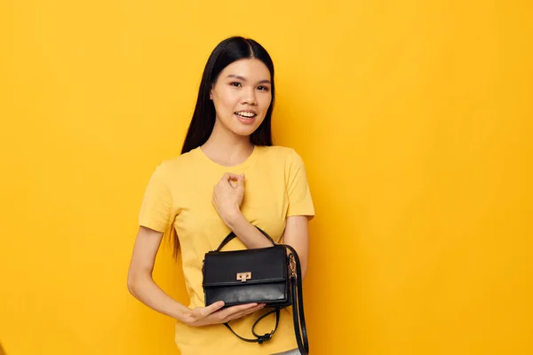Kvinna hona koppling tillbehör poserar gul bakgrund oförändrad — Stockfoto