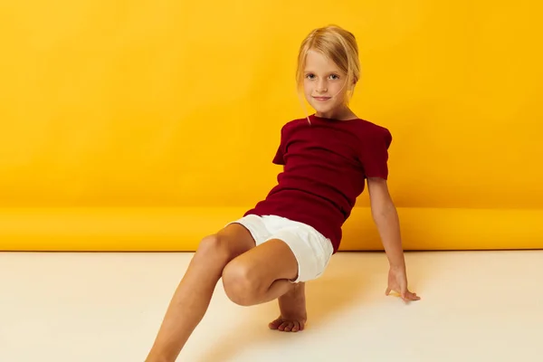 Kislány ül a padlón pózol alkalmi ruhák — Stock Fotó