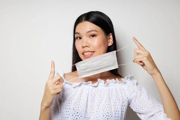 Portrait Asian cantik wanita muda menghadapi keselamatan perisai close-up latar belakang cahaya yang tidak berubah — Stok Foto