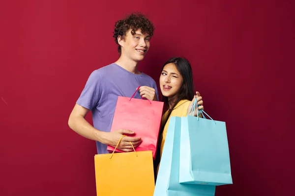 Молодий хлопчик і дівчинка барвисті сумки покупки весело ізольований фон незмінний — стокове фото