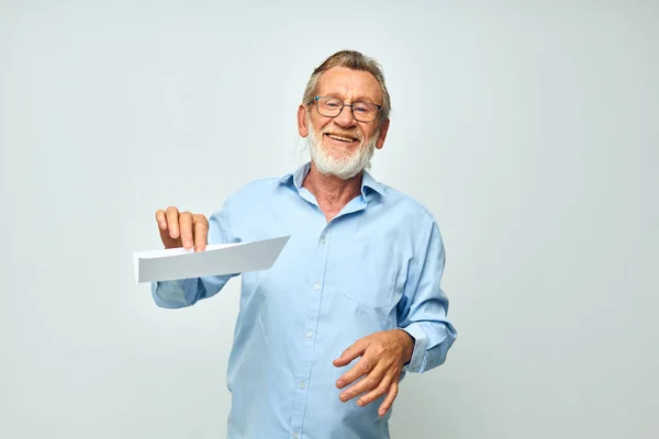 Старший седовласый мужчина держит лист бумажного копировального пространства на изолированном фоне — стоковое фото