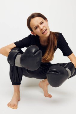 Siyah pantolonlu, boks eldivenli genç bir kadın.