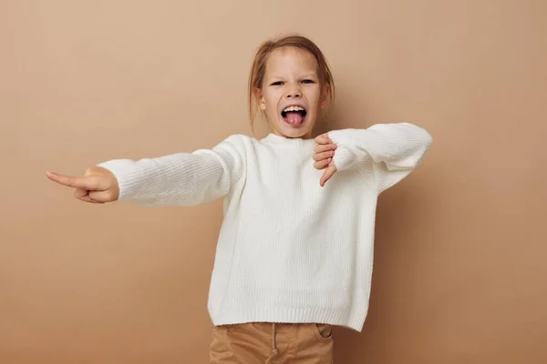Malá dívka v bílém svetru pózuje gesta rukou izolované pozadí — Stock fotografie