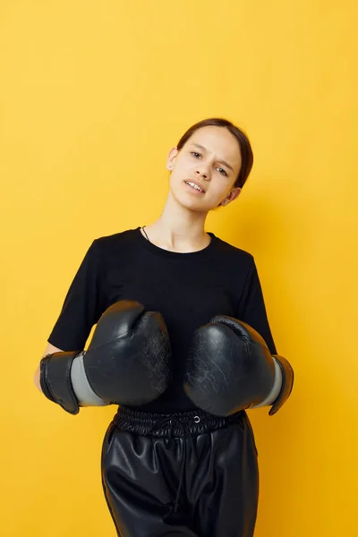 Jonge vrouw zwart bokshandschoenen poseren gele achtergrond sport — Stockfoto