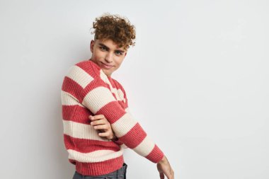 Çizgili kazaklı yakışıklı adam yaşam tarzını değiştirmeden poz veriyor.