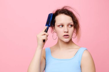 Güzel bir kadın saçlarını taramaktan hoşlanmaz pembe arka plan değişmez