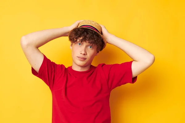 Chico con rojo rizado pelo emociones rojo camiseta sombrero estudio amarillo fondo inalterado — Foto de Stock