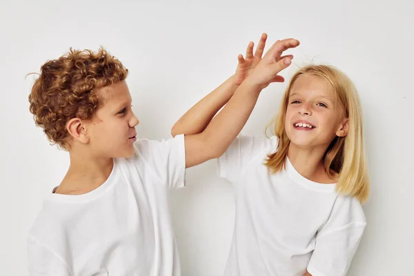 Fotografie dvou dětí v bílých tričkách stojí vedle dětství beze změny — Stock fotografie