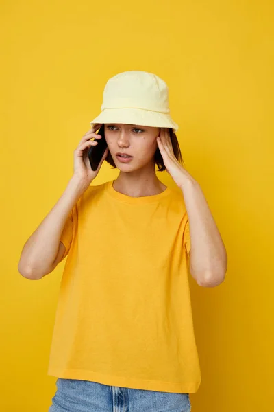 Optimista mujer joven en un sombrero amarillo estilo juvenil casual hablando por teléfono Estilo de vida inalterado — Foto de Stock