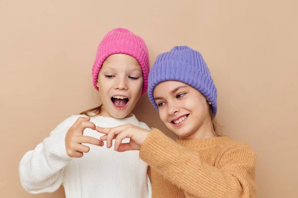 两个滑稽的女孩抱着五颜六色的帽子 — 图库照片