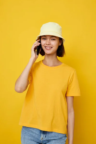 Αισιόδοξη νεαρή γυναίκα σε ένα κίτρινο καπέλο Νεανικό στυλ casual μιλώντας στο τηλέφωνο Lifestyle αμετάβλητη — Φωτογραφία Αρχείου